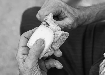 Close-up de homem a cortar pão e queijo